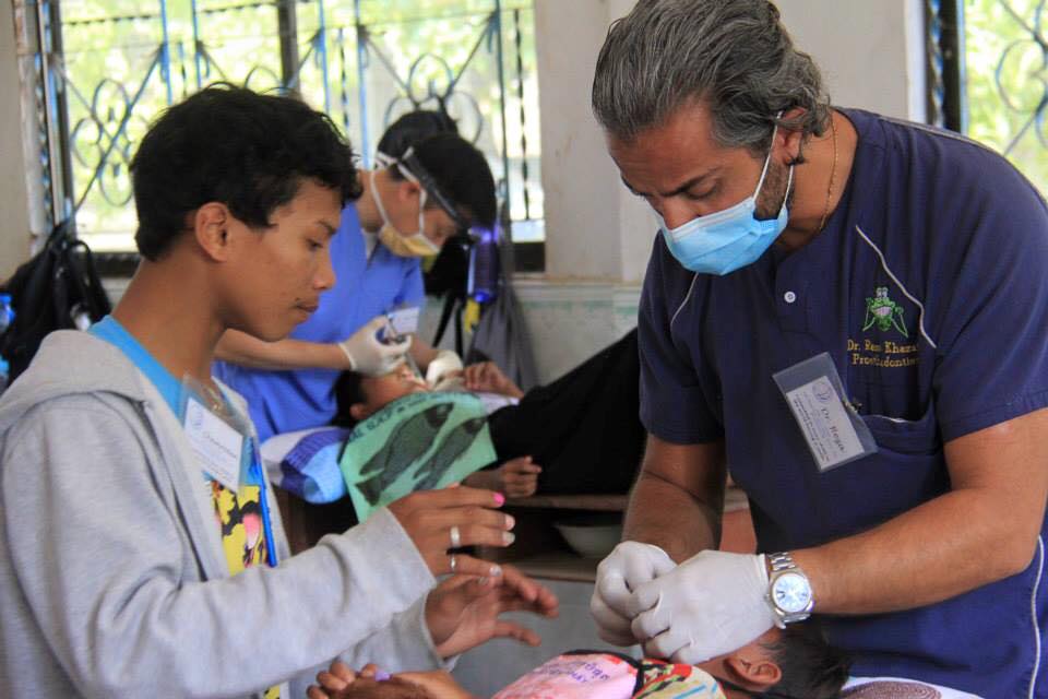 Dr. Reza Khazaie providing dental care on child in Cambodia