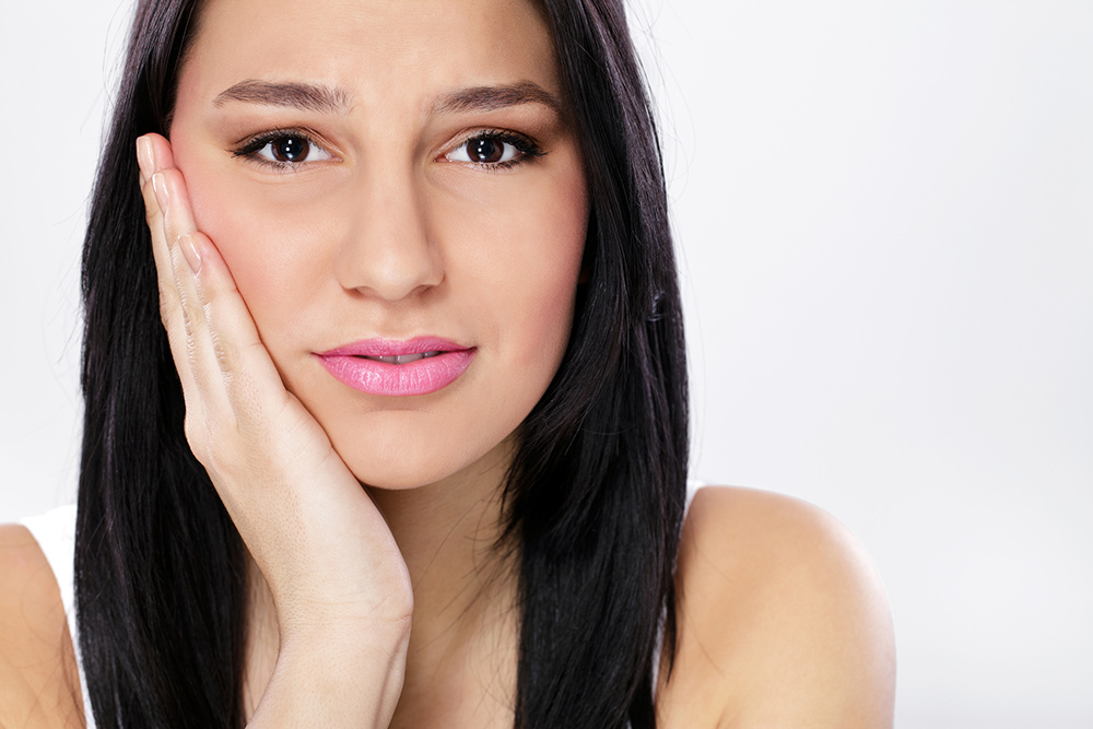 Woman with jaw pain, TMJ, TMD - Dentist in Concord