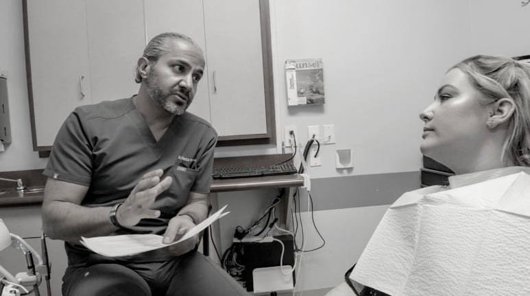 Dr. Reza Khazaie talking with patient about dental implants